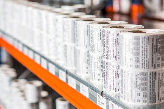 Gestapelte Rollen von Industrieetiketten im Regal